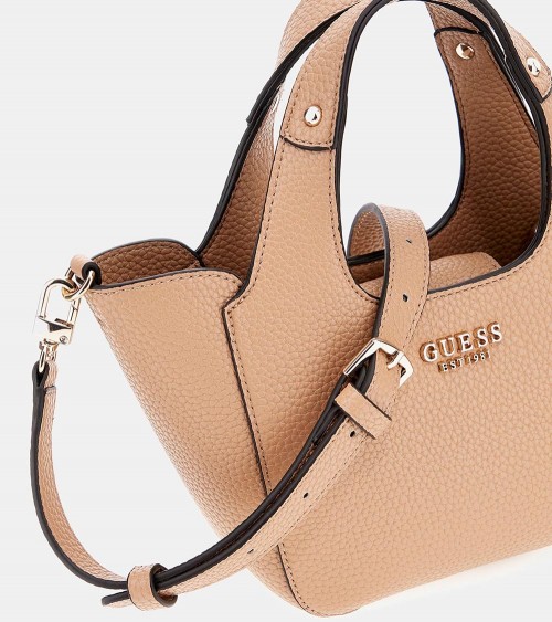 Bolso Guess Helina en color beige, sostenido por una modelo, ideal para looks elegantes.