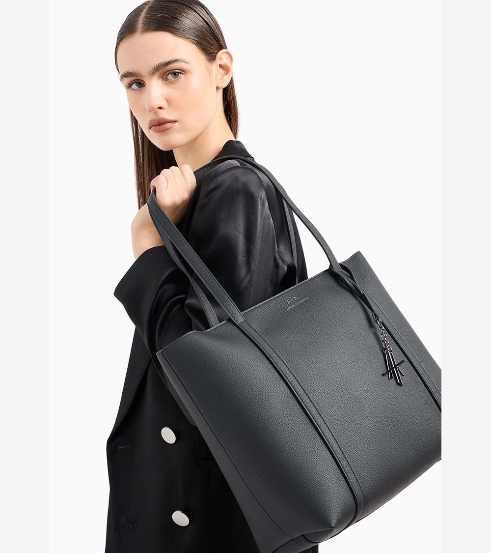 Mujer llevando el elegante bolso shopper negro de Armani Exchange, perfecto para cualquier ocasión casual.