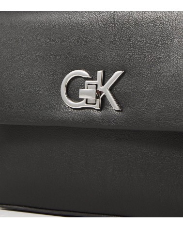 Detalle del logo metálico CK en el bolso Calvin Klein negro.